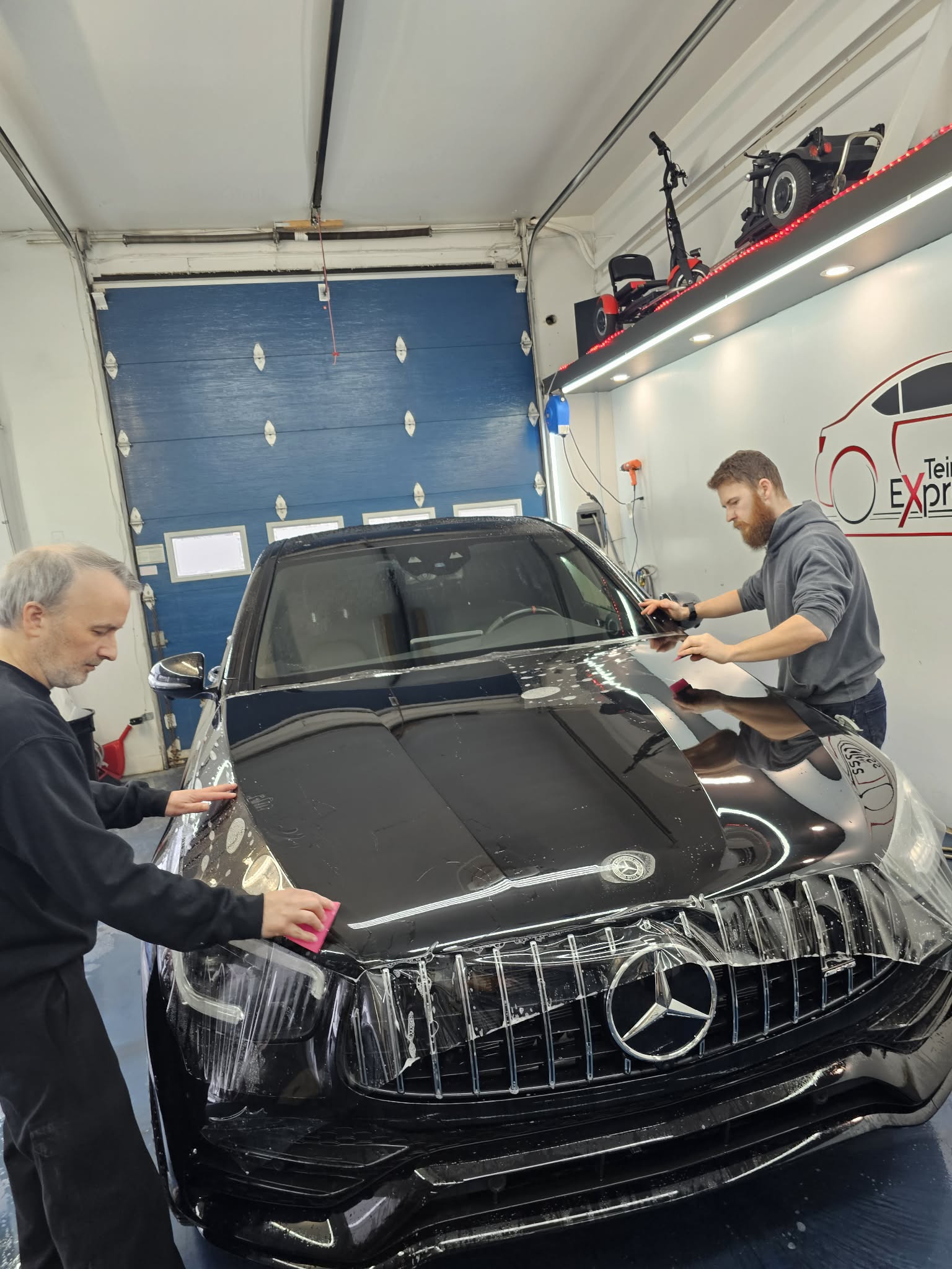 Installation de pare-pierre sur une Mercedes noire en atelier