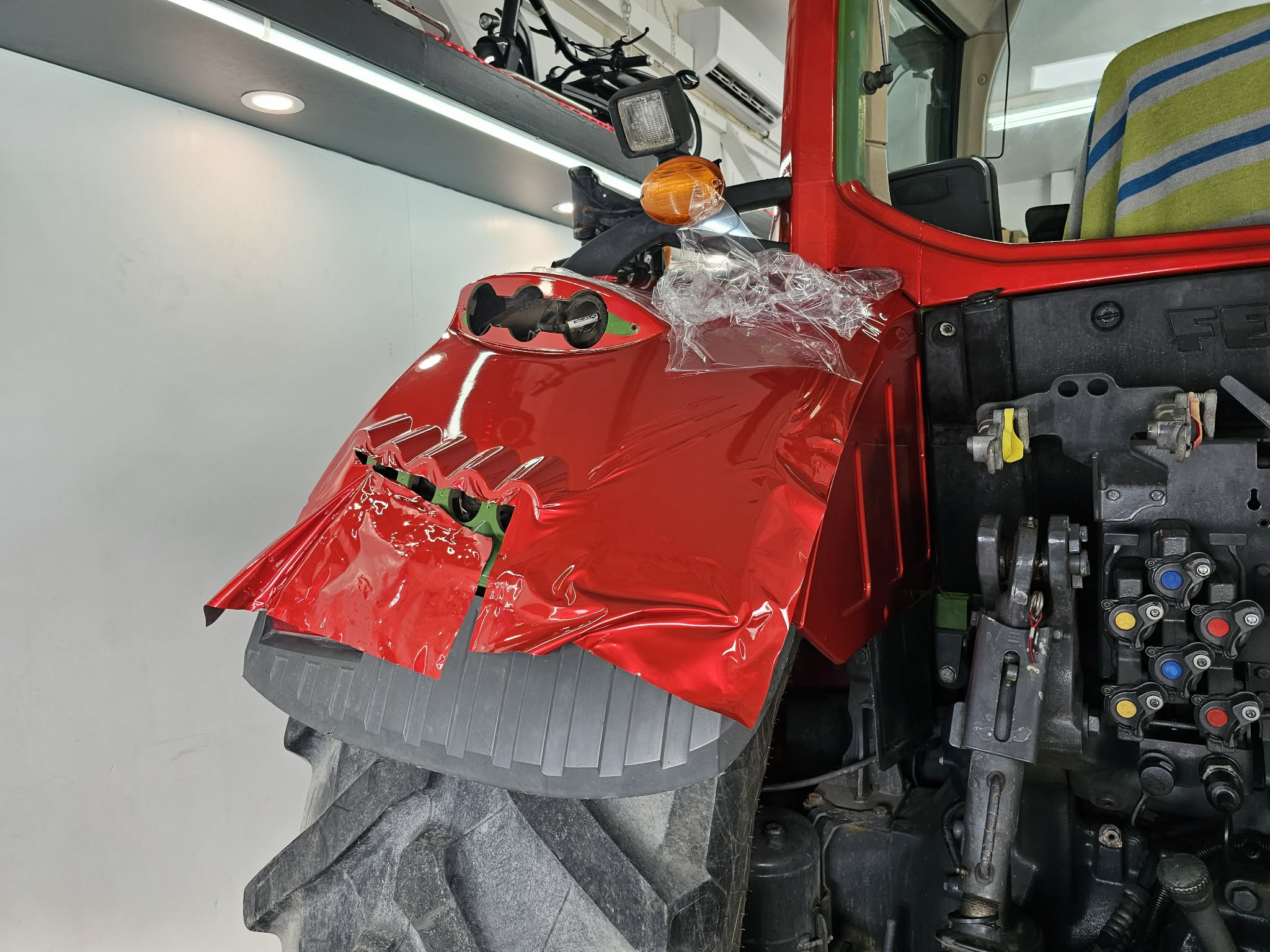 Detail d'un film rouge applique sur une piece de machinerie comme exemple de wrapping sur demande